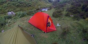 Image showing the bright Orange Vaude Hogan UL Argon pitched next to the modest green MSR tent.