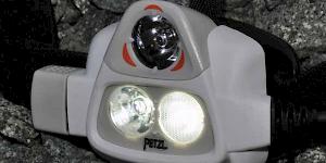 Close up image of the Petzl Nao 575L showing the light sensor at the top and the two lamps below. to the left of the picture the control dial can be seen.