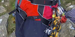 Side-on image showing the DMM Super Couloir being worn, clearly showing the quick release leg buckles, double back buckle waist closure and the simple waist attachment through the belay loop.